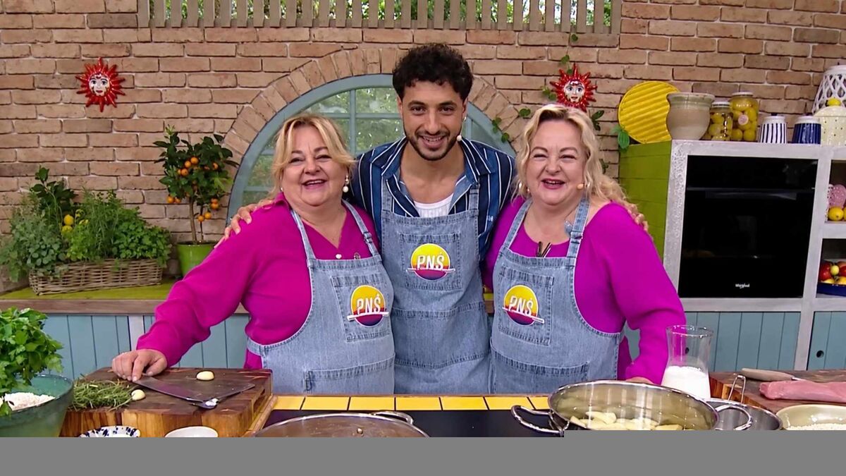 Ewa Rogalska, Adrian Królikowski i Agnieszka Kuszewska stoją razem za kuchennym blatem. Wszyscy mają na sobie szare fartuchy, a kobiety dodatkowo różowe bluzki. W tle widoczne są ceglana ściana, rośliny, półki oraz naczynia i produkty spożywcze.